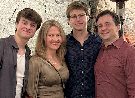 Dr. Kelly Jordan-Sciutto smiles with her husband Mark and their two sons Jay and Alec at a family gathering.