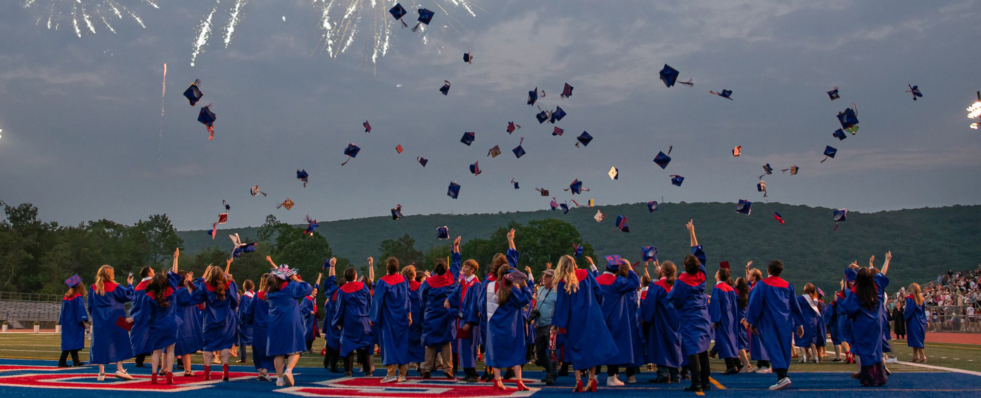 Graduates toss caps at commencement with text: Welcome to the North Schuylkill School District, Home of The Spartans