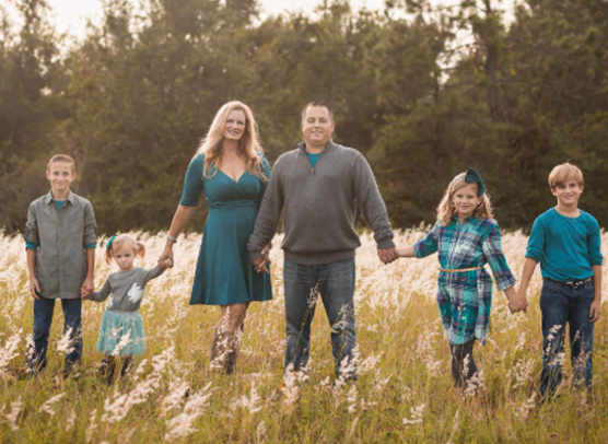 Bill Wydra Jr. poses outdoors with his wife Angela and their children in a family portrait.
