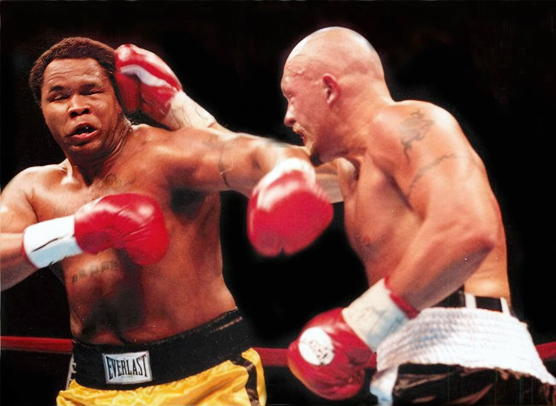 Dennis Maley throws a right hook at opponent Willie Herring during a professional boxing match.